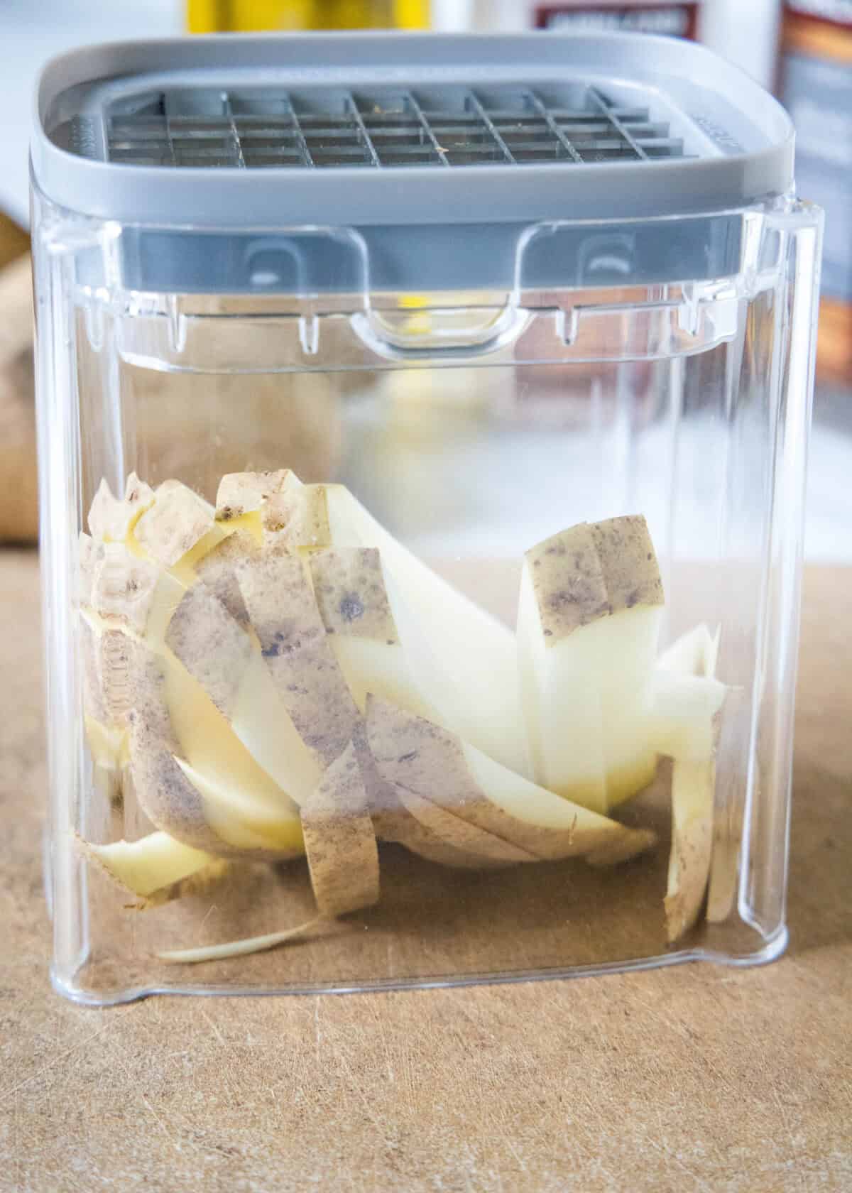 Homemade air fryer French fries are just as crispy as regular fries! Make them in a fraction of the time, with any seasonings you’d like. Potatoes cut into fries inside a potato cutter.