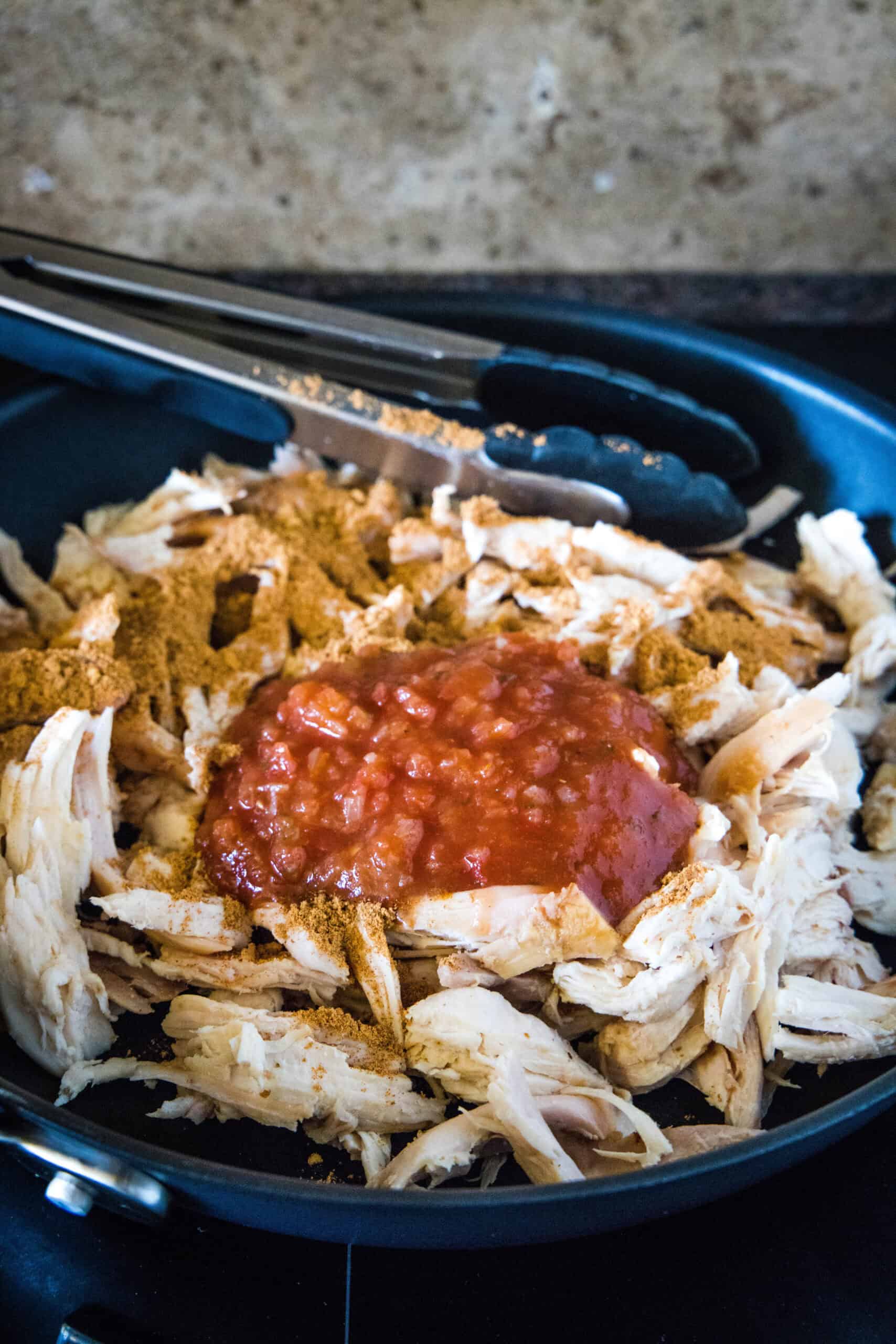 Juicy rotisserie chicken tacos are the best shortcut on taco night! Make delicious, easy chicken tacos in 15 minutes with only 3 ingredients. Seasonings and salsa added to shredded rotisserie chicken in a skillet.
