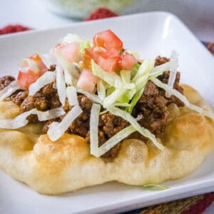 cropped close up indian fry bread taco on a white plate