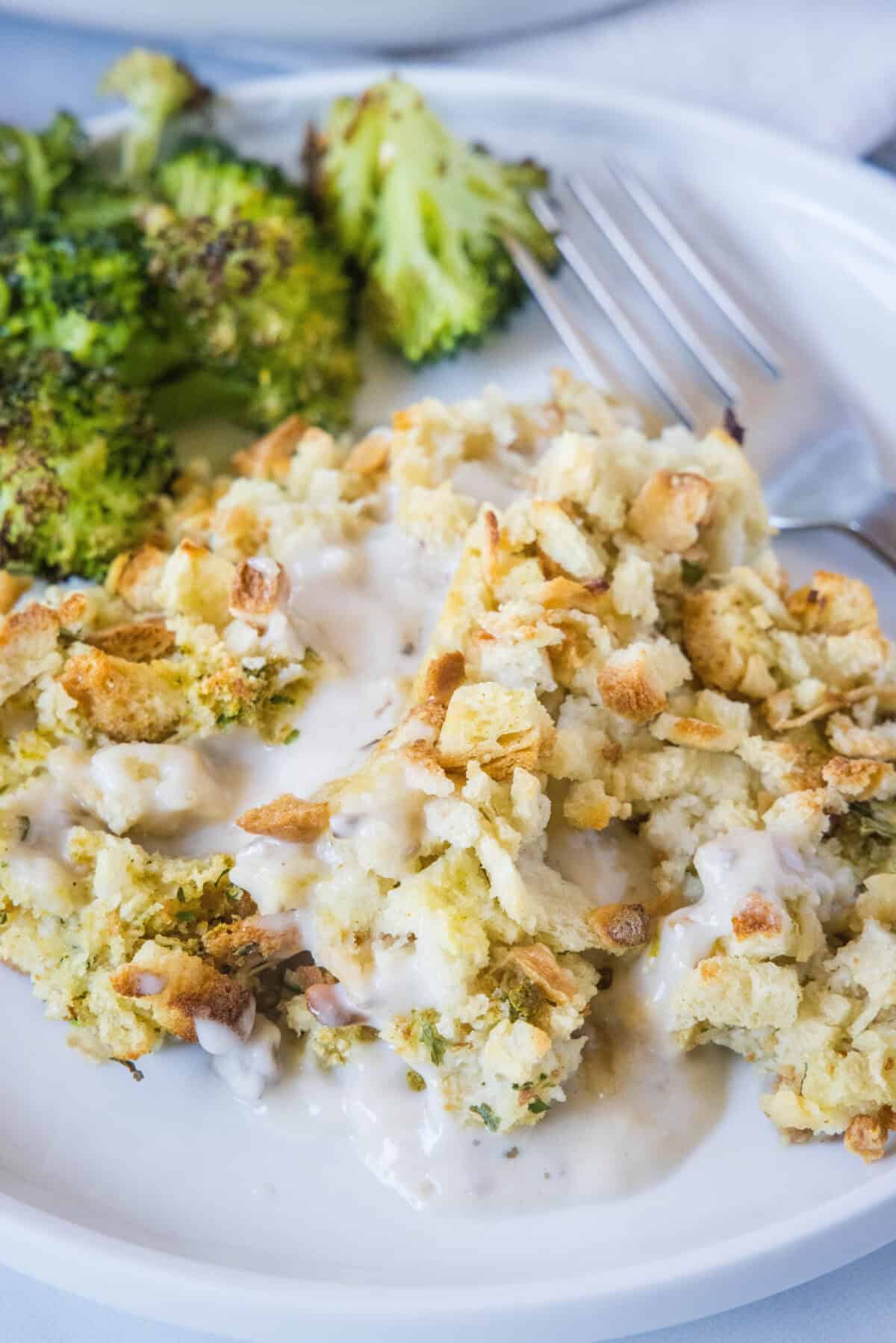 serving of chicken stuffing casserole on a plate with broccoli