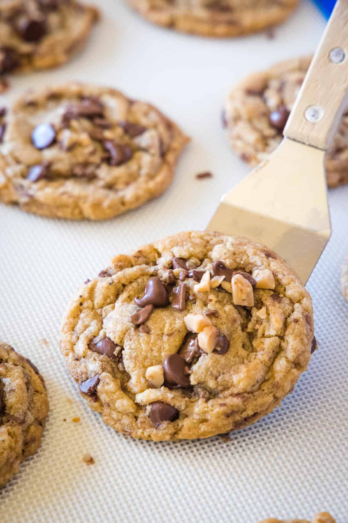 scooping toffee cookies off baking tray