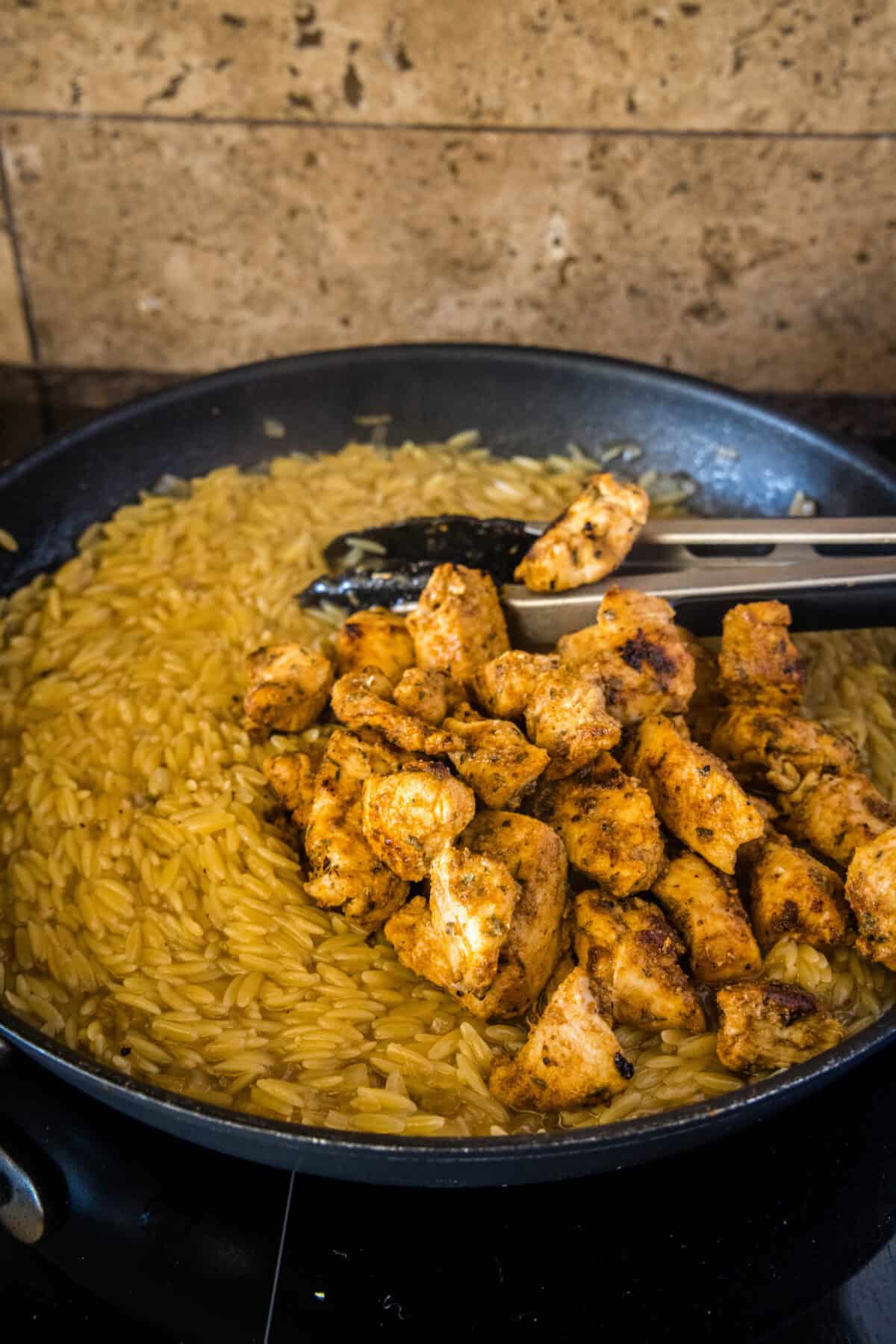adding chicken back to the pan with orzo