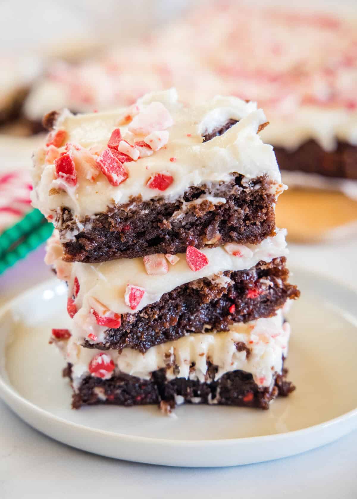 christmas brownies stacked on a white plate