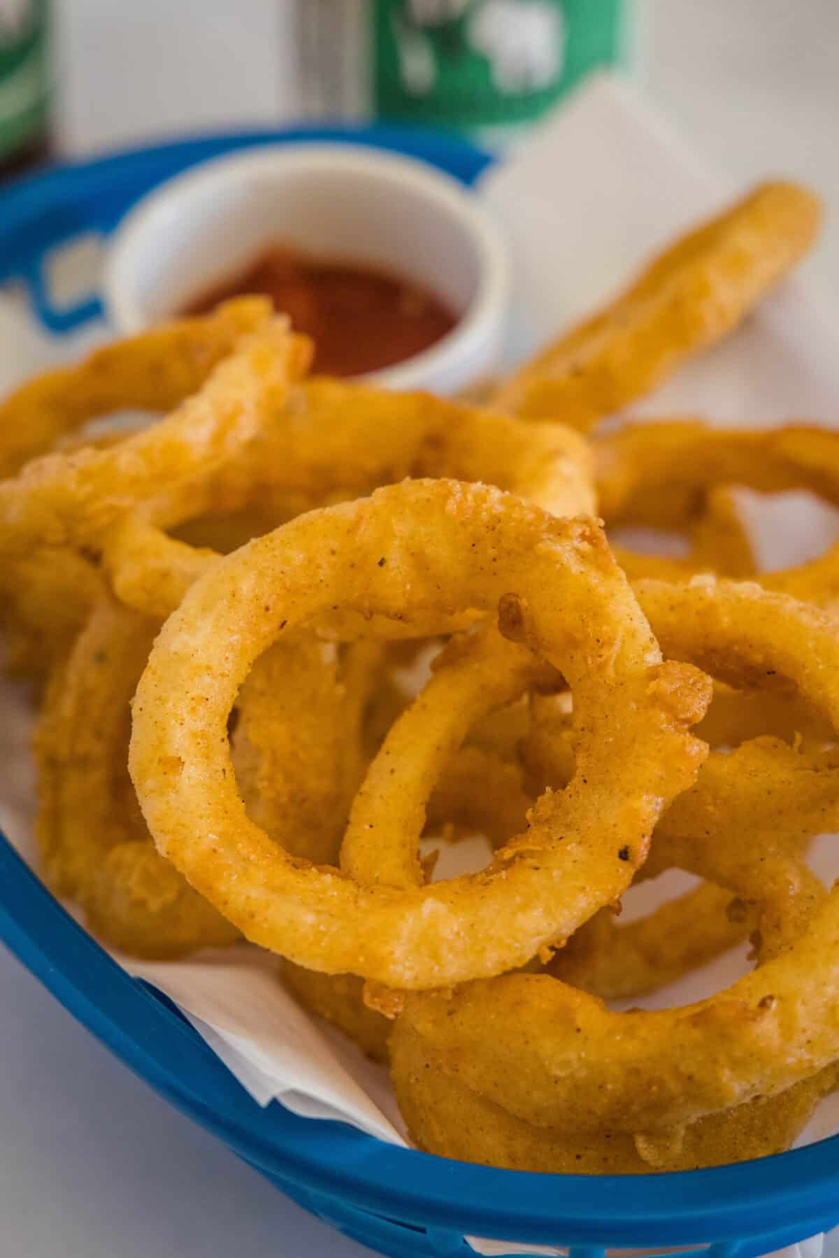 onion rings in a basket with ketchup