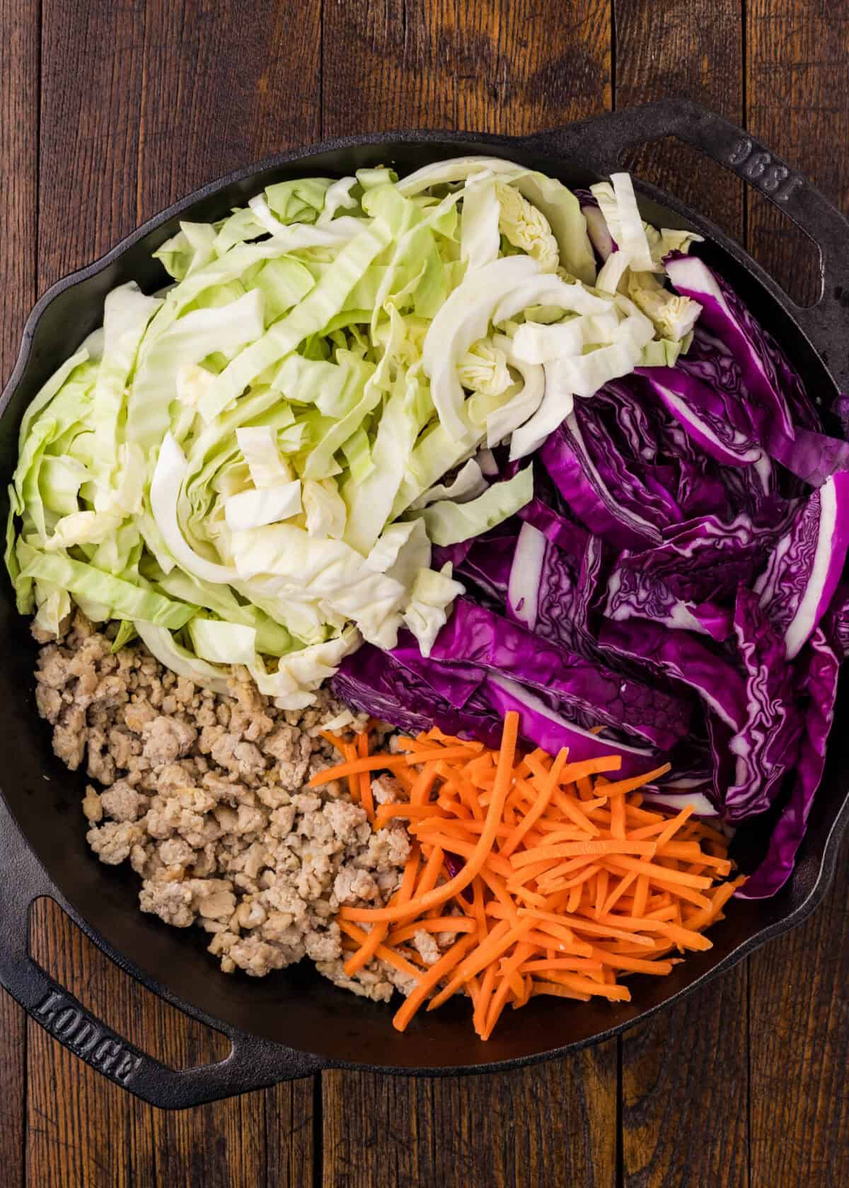 adding vegetables to the skillet with ground chicken