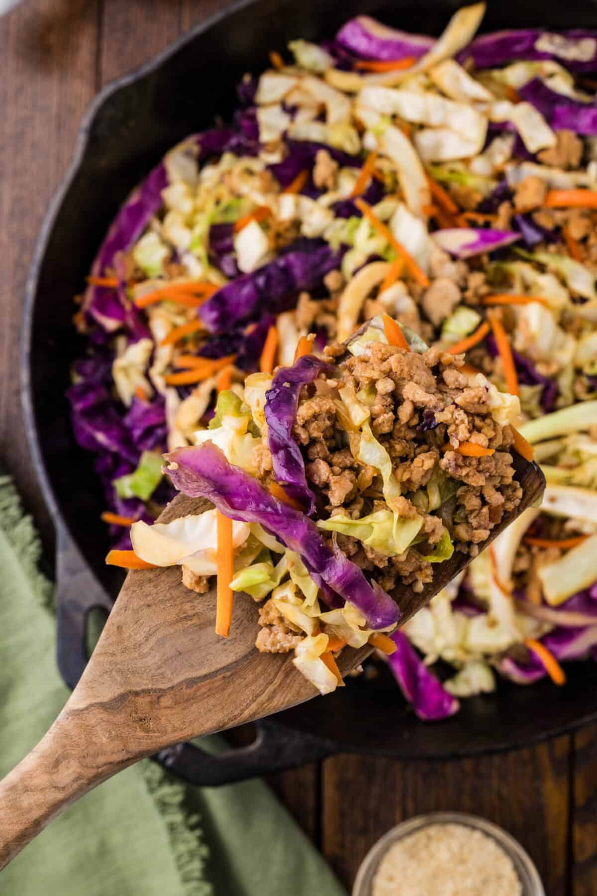 scooping chicken egg roll bowl out of skillet