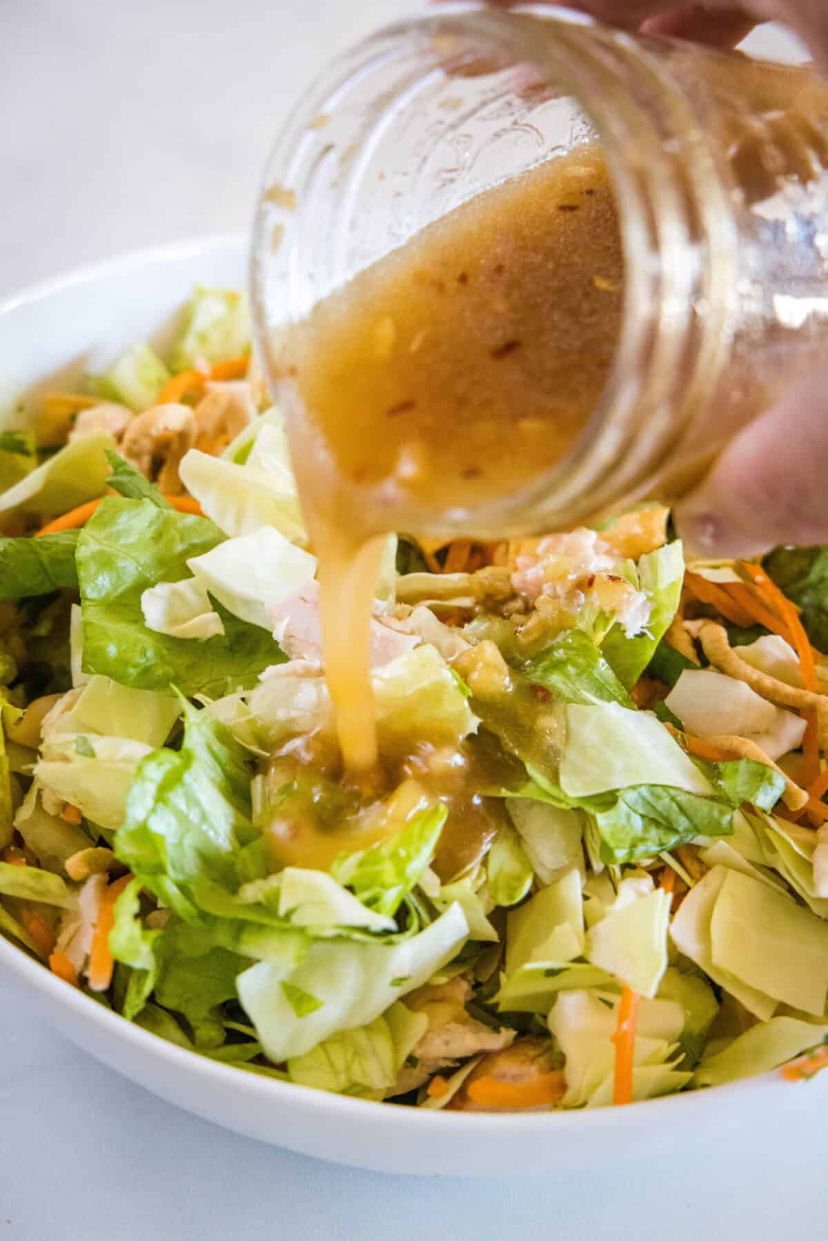 pouring dressing over salad