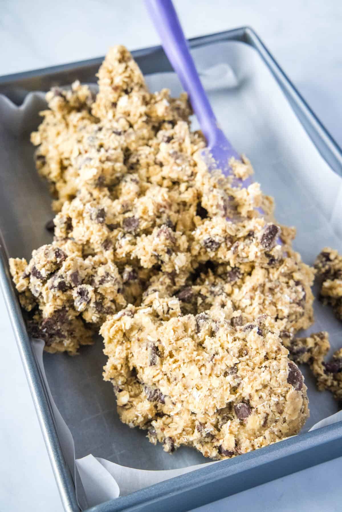 spreading cookie dough into baking pan