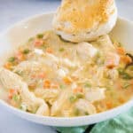 cropped slow up chicken pot pie in a bowl with a biscuit