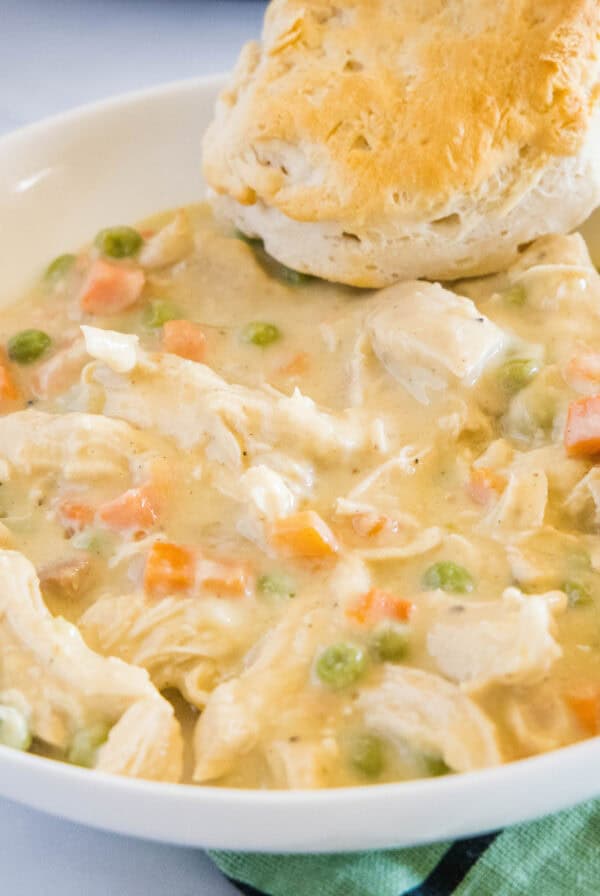 cropped slow up chicken pot pie in a bowl with a biscuit