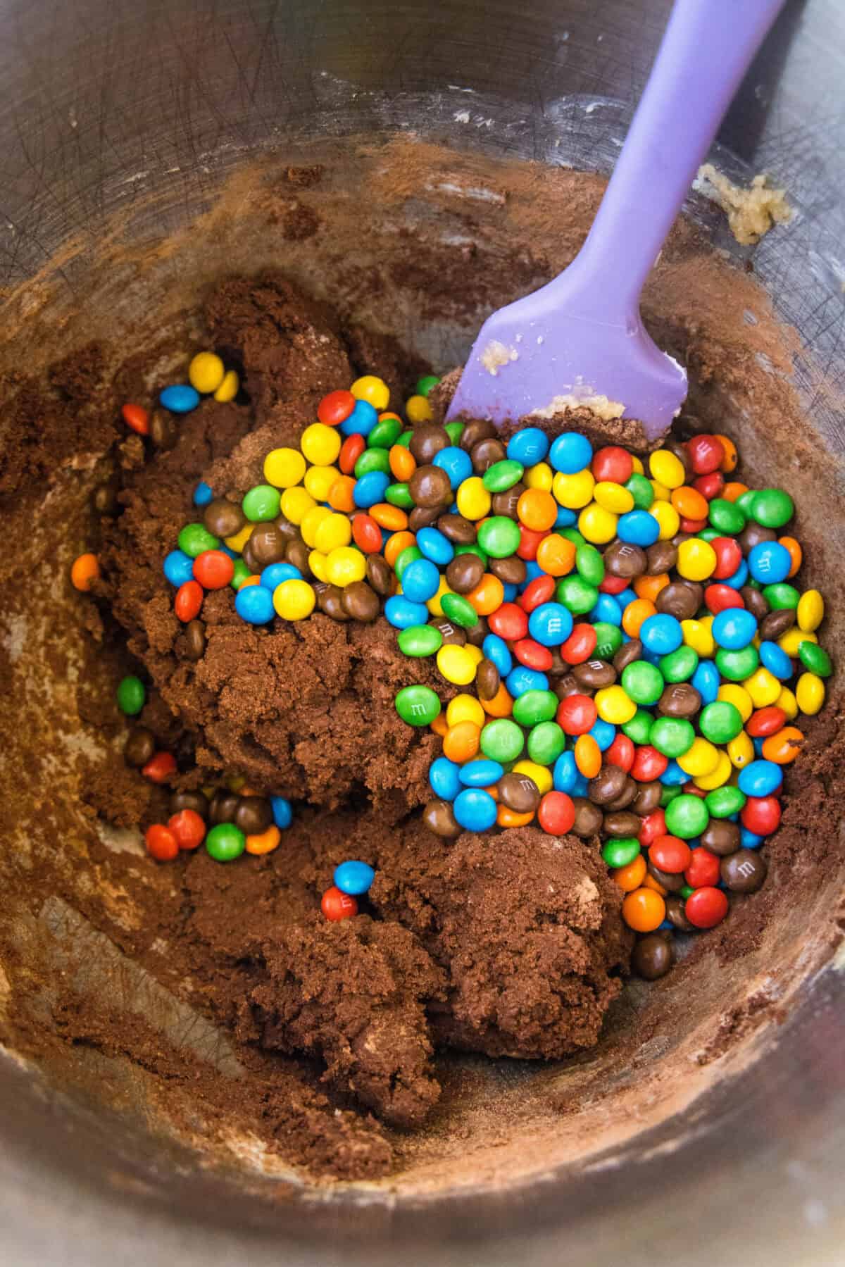 adding mini M&M's to cookie dough