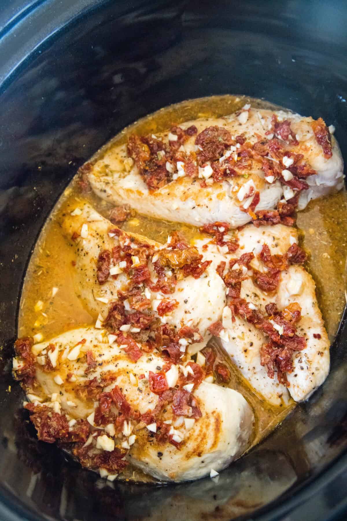 chicken in the crockpot topped with sun dried tomatoes