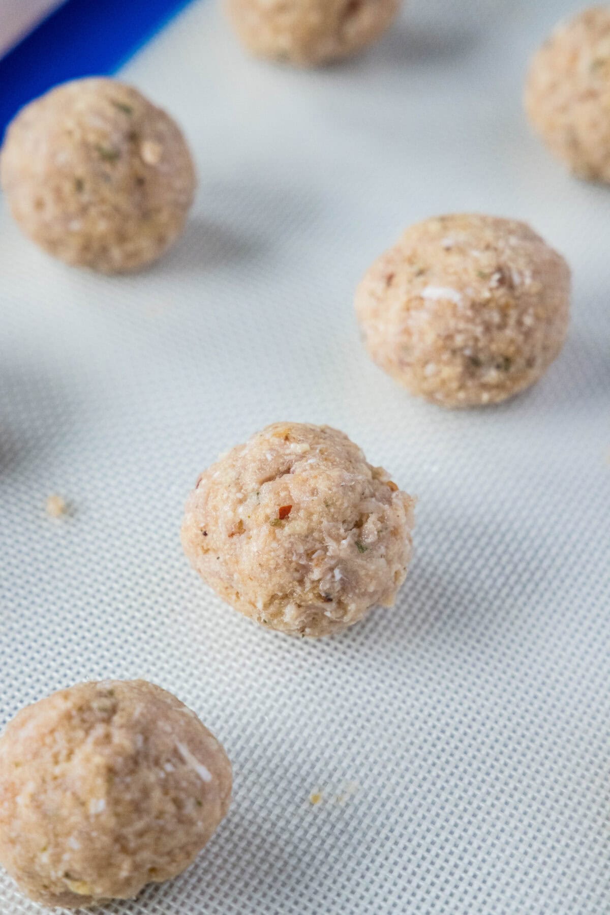 rolled chicken meatballs on baking sheet