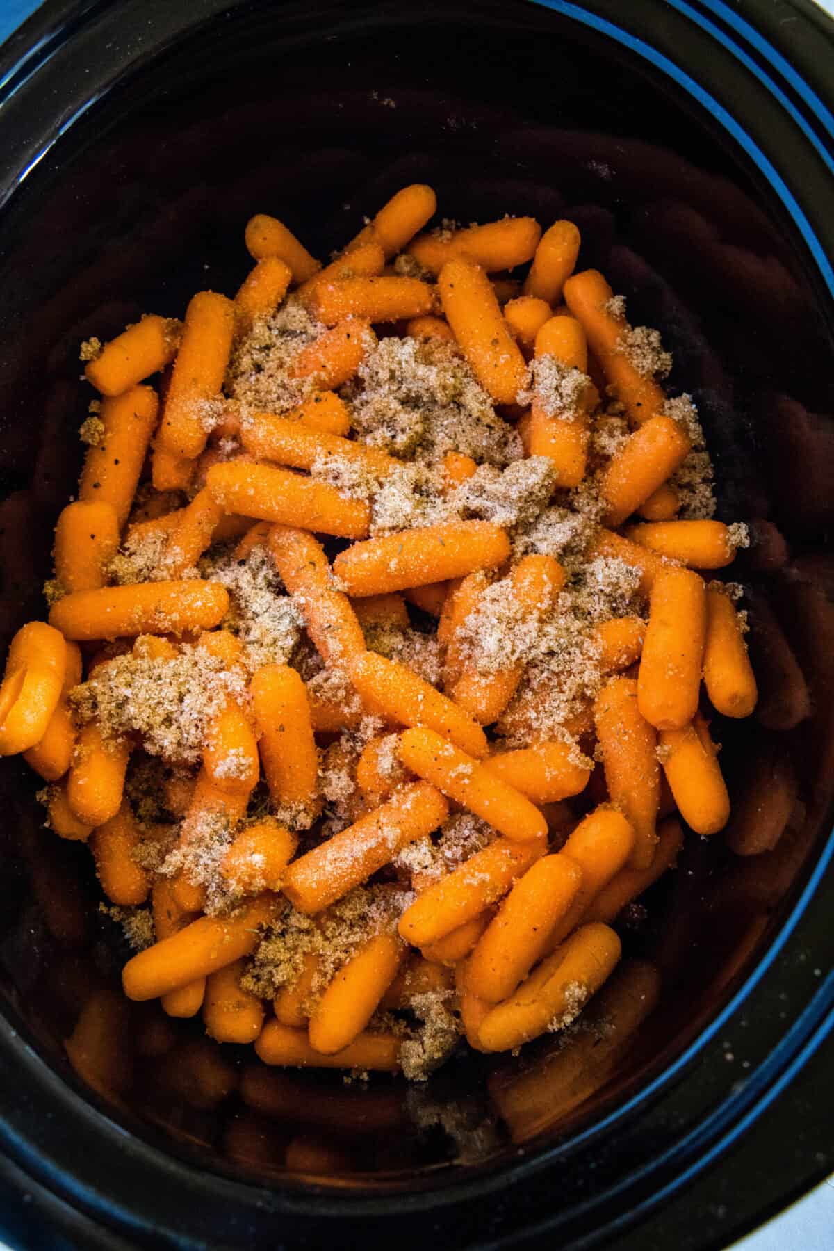 seasoning sprinkled over carrots in crockpot