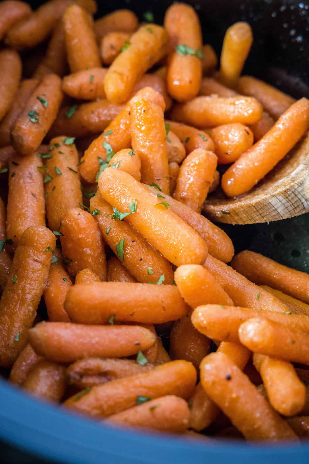 roasted carrots in crockpot with spoon