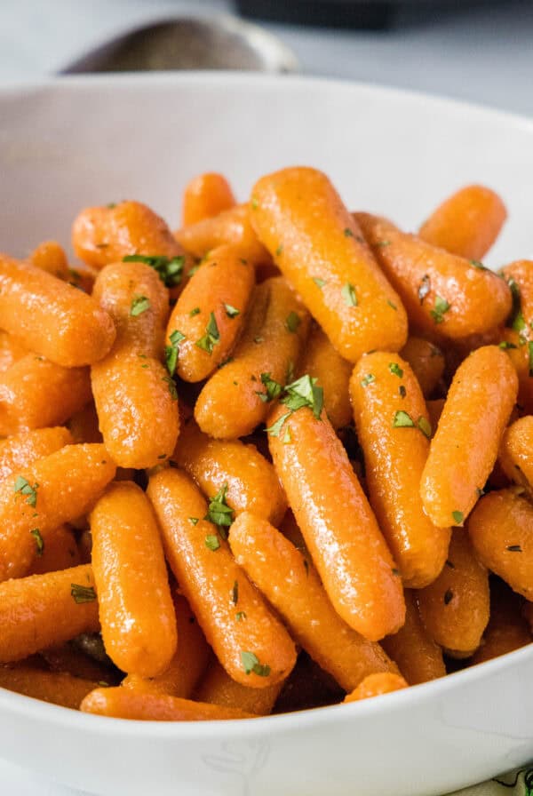 close up slow cooker roasted carrots in serving bowl