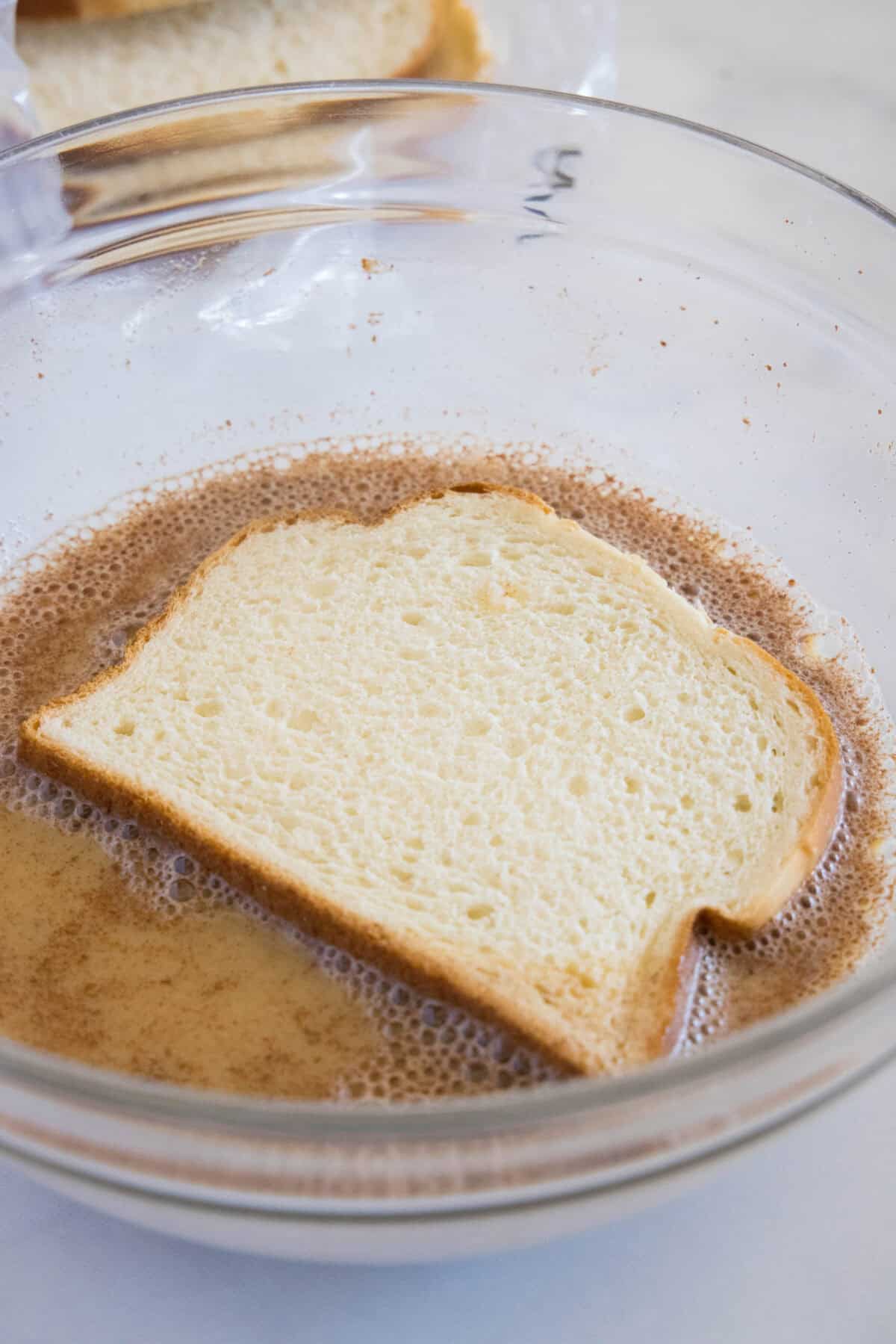 dipping bread in custard mixture for french toast