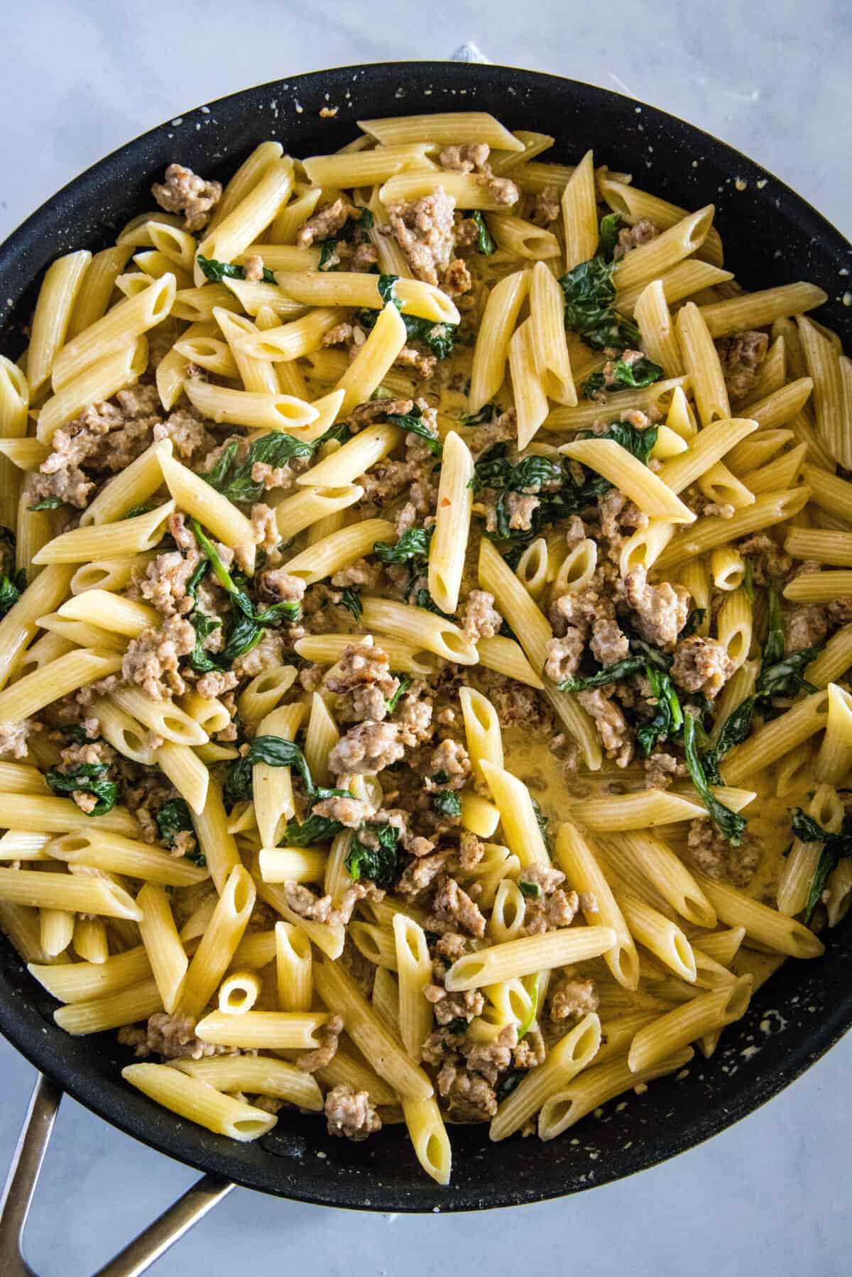 looking down on a pan with sausage pasta with spinach