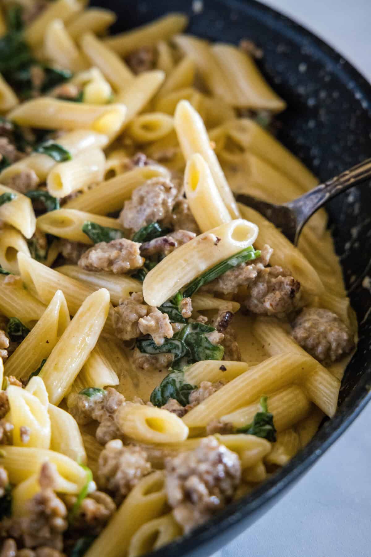 sausage pasta spinach in a skillet