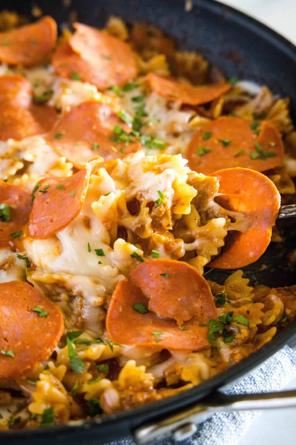 scooping pasta out of a skillet
