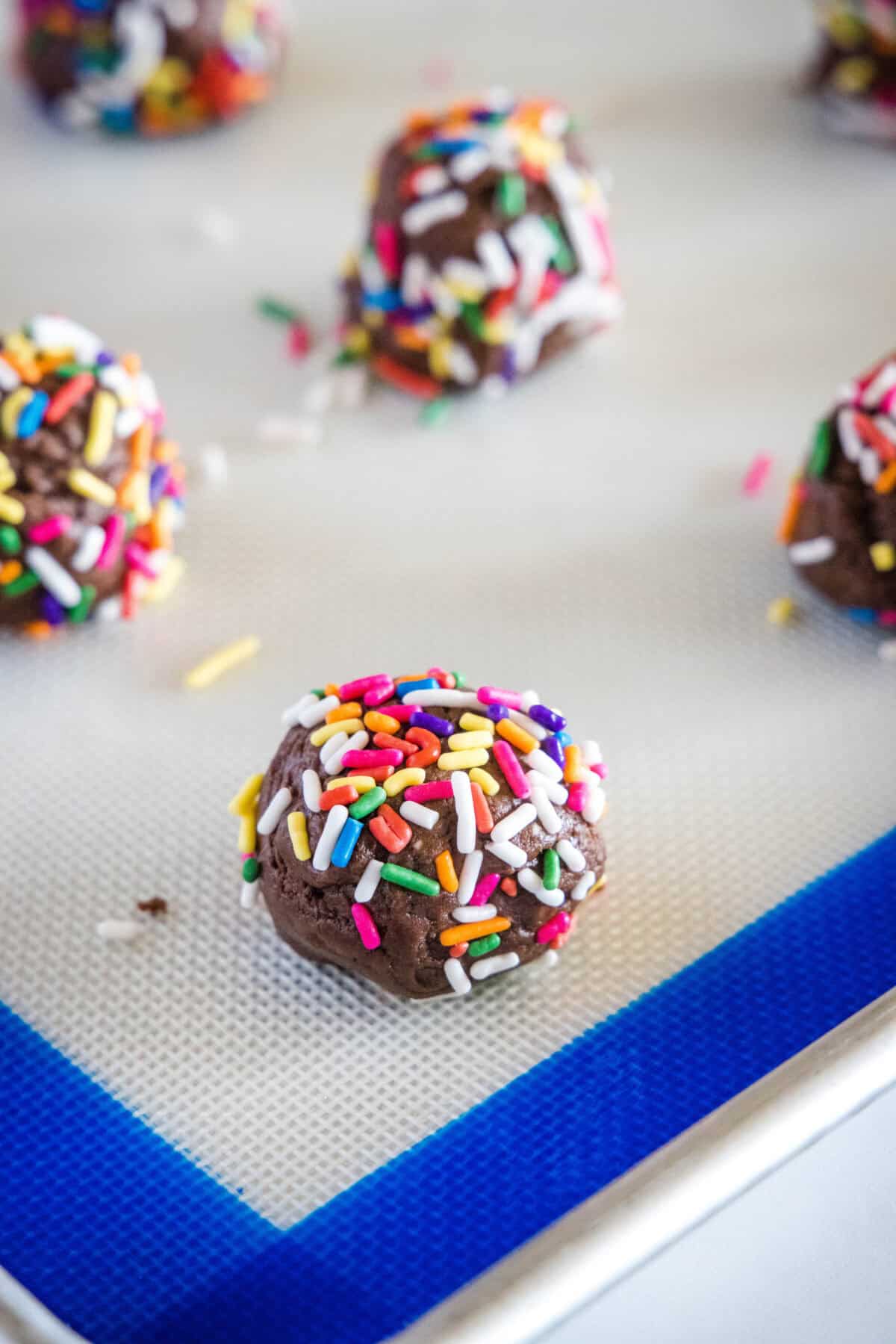 balls of chocolate sprinkle cookies on baking tray
