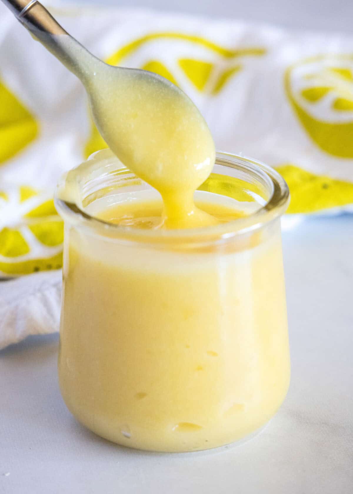 spooning lemon curd out of a jar