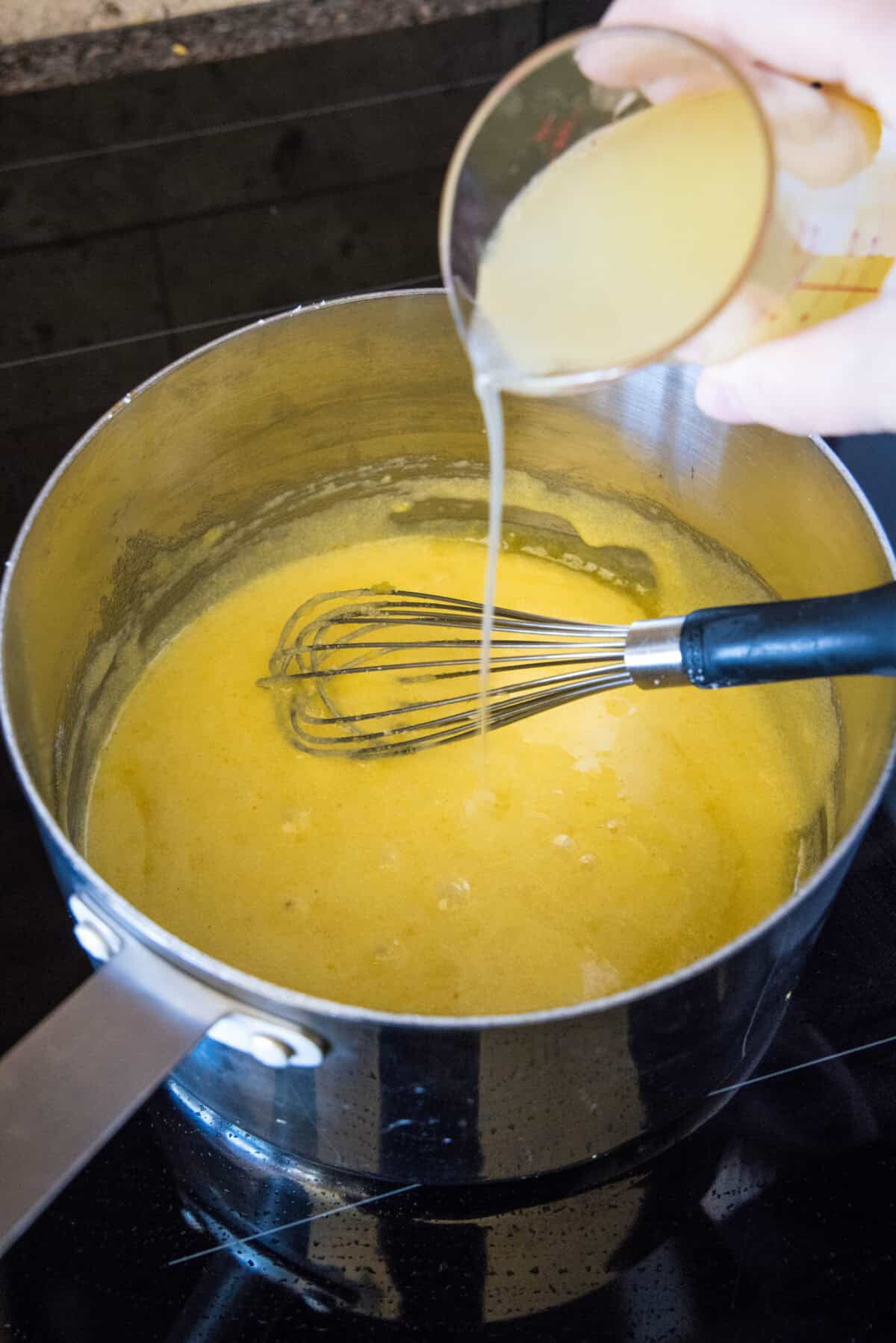 pouring lemon juice into saucepan