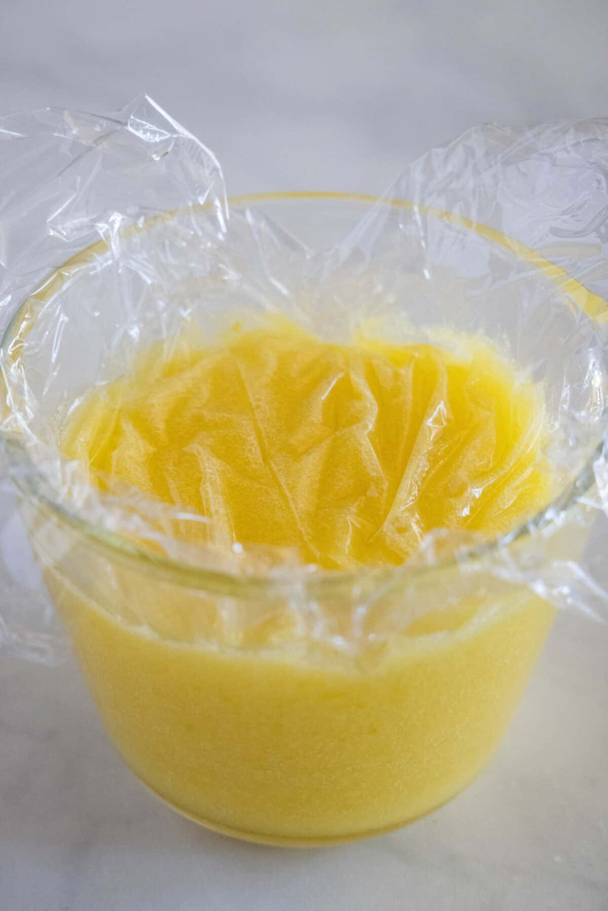 plastic wrap over jar of lemon curd