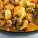 close up ravioli with sausage in a skillet