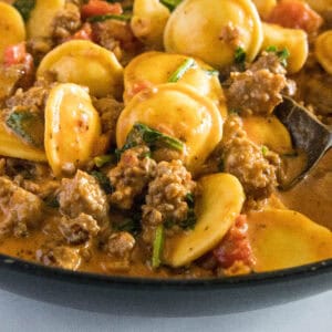 close up ravioli with sausage in a skillet