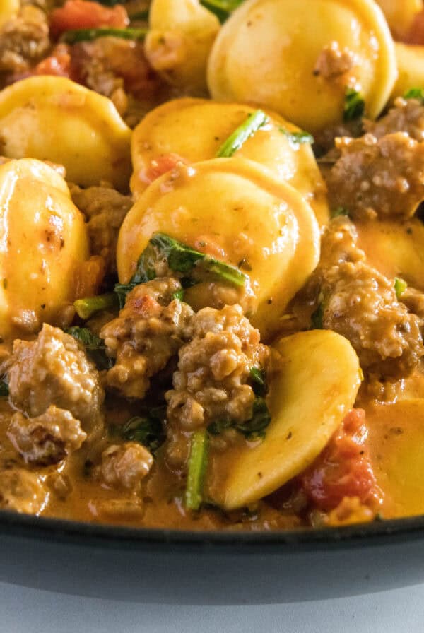close up ravioli with sausage in a skillet