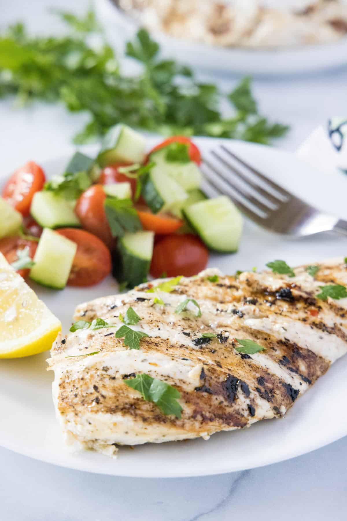 yogurt marinated chicken on a plate with greek salad