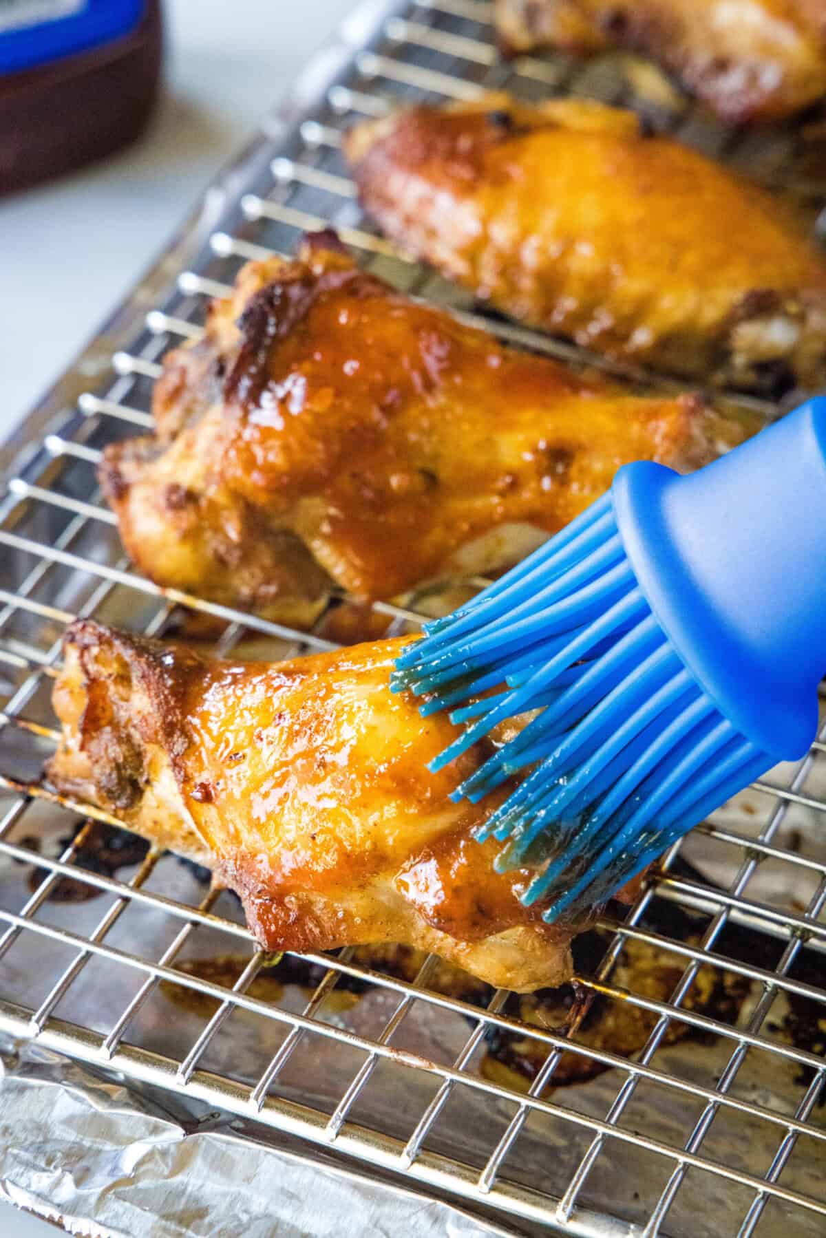 brushing bbq sauce on baked chicken wings