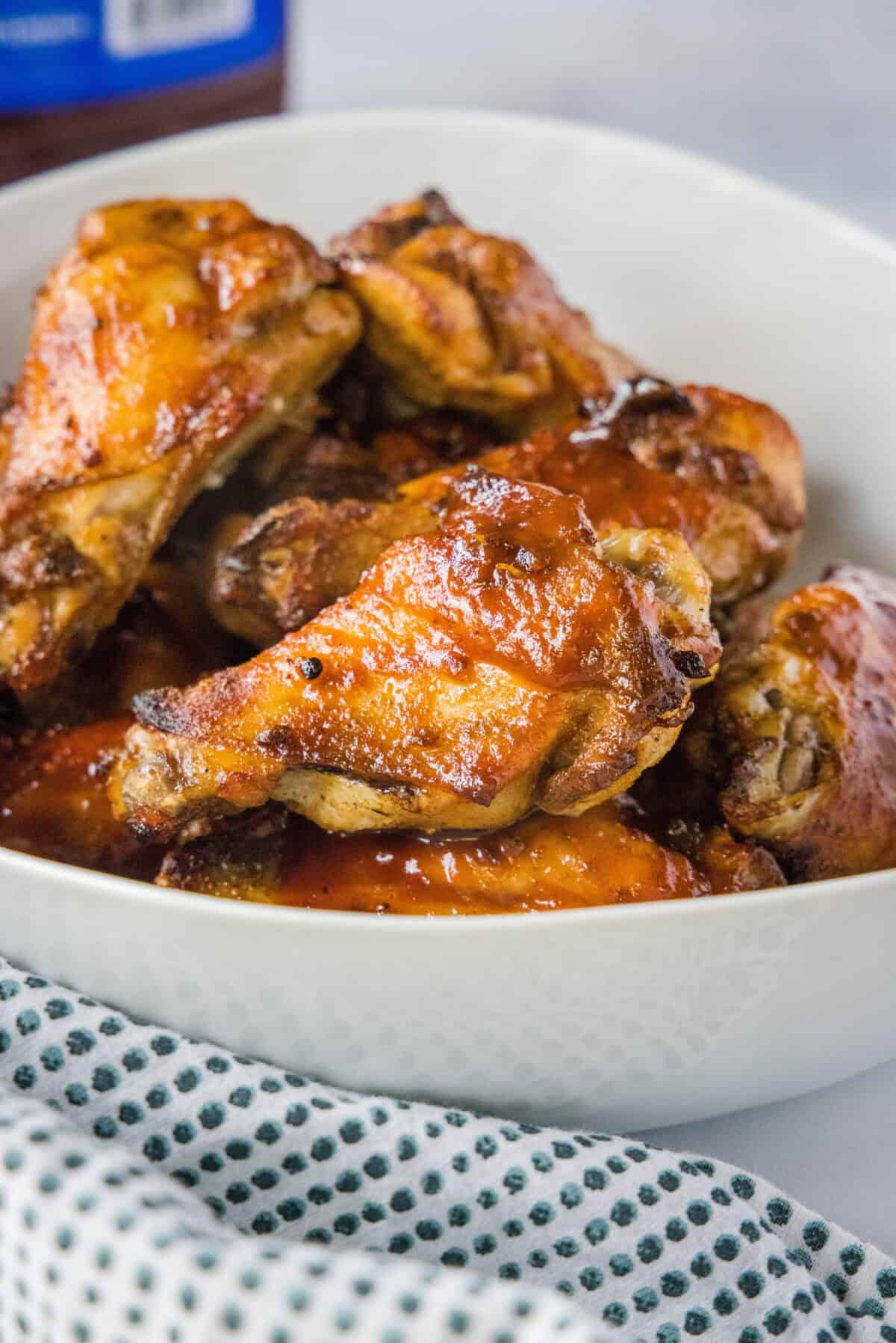 baked chicken wings coated with bbq sauce in a bowl