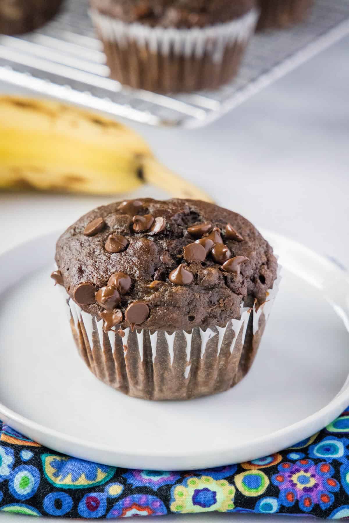 Banana Chocolate Chip Muffins | Dinners, Dishes, and Desserts chocolate banana muffin on a plate