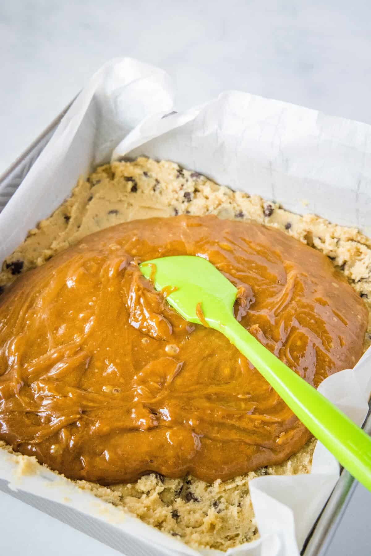 spreading biscoff caramel over cookie dough