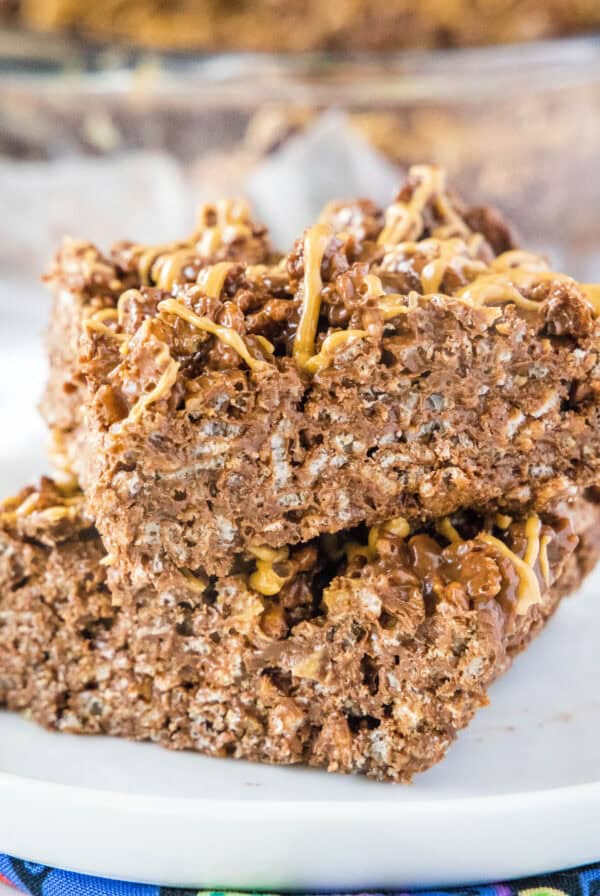 chocolate peanut butter krispie bars staked on a white plate