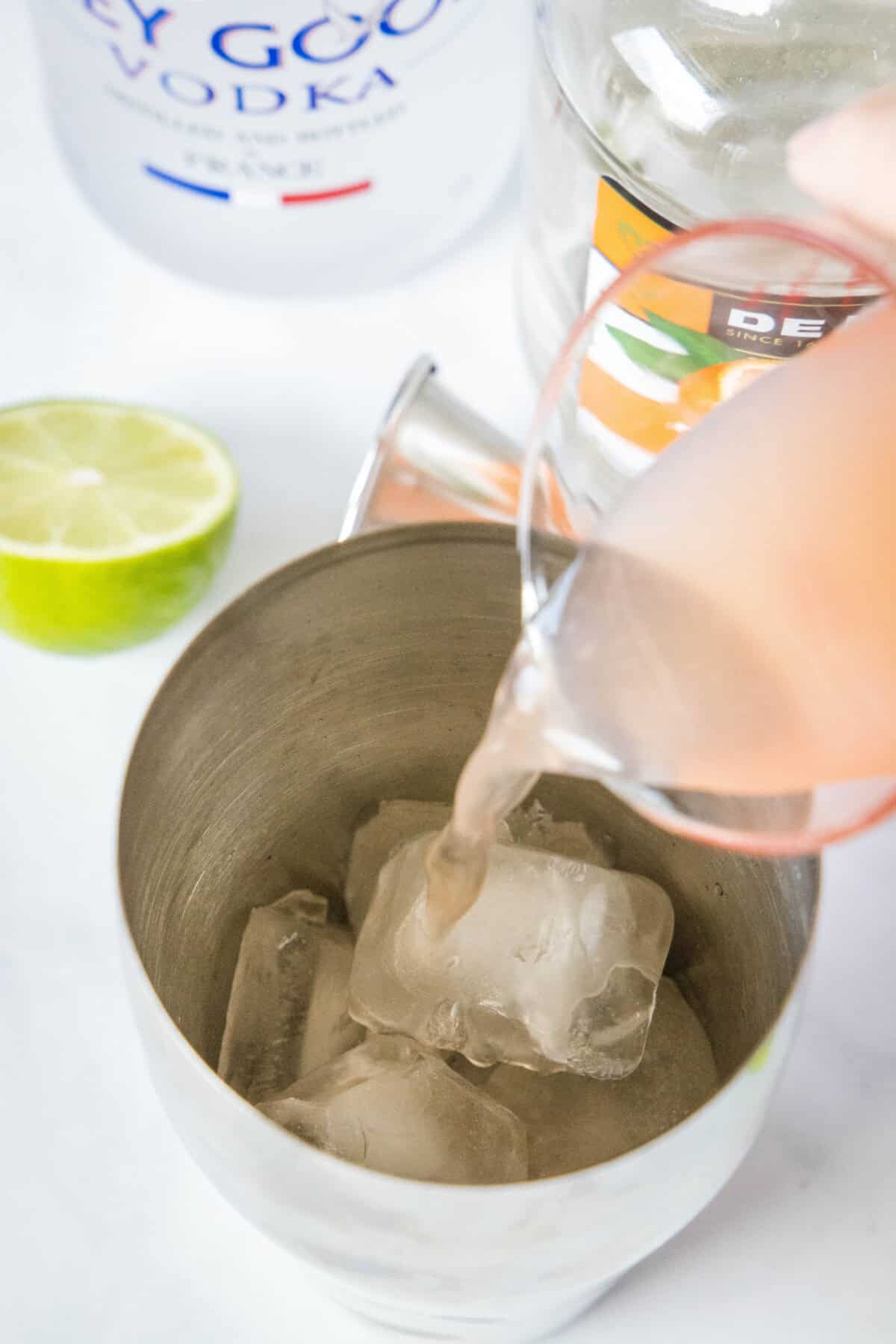 pouring grapefruit juice into a shaker