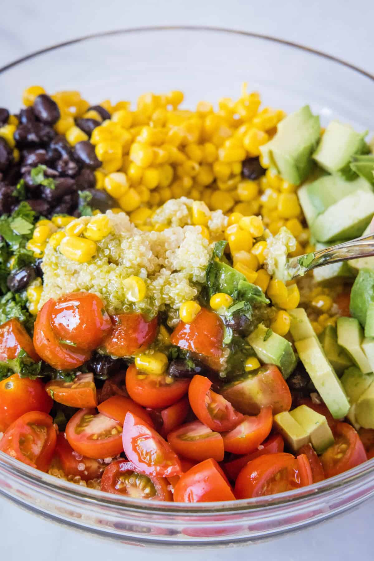 mixing quinoa salad in a mixing bowl