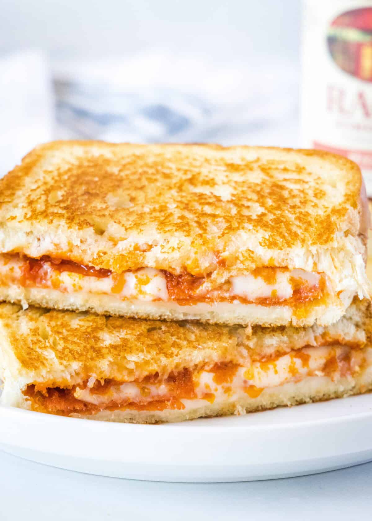 pizza grilled cheese sandwich cut in half on a plate