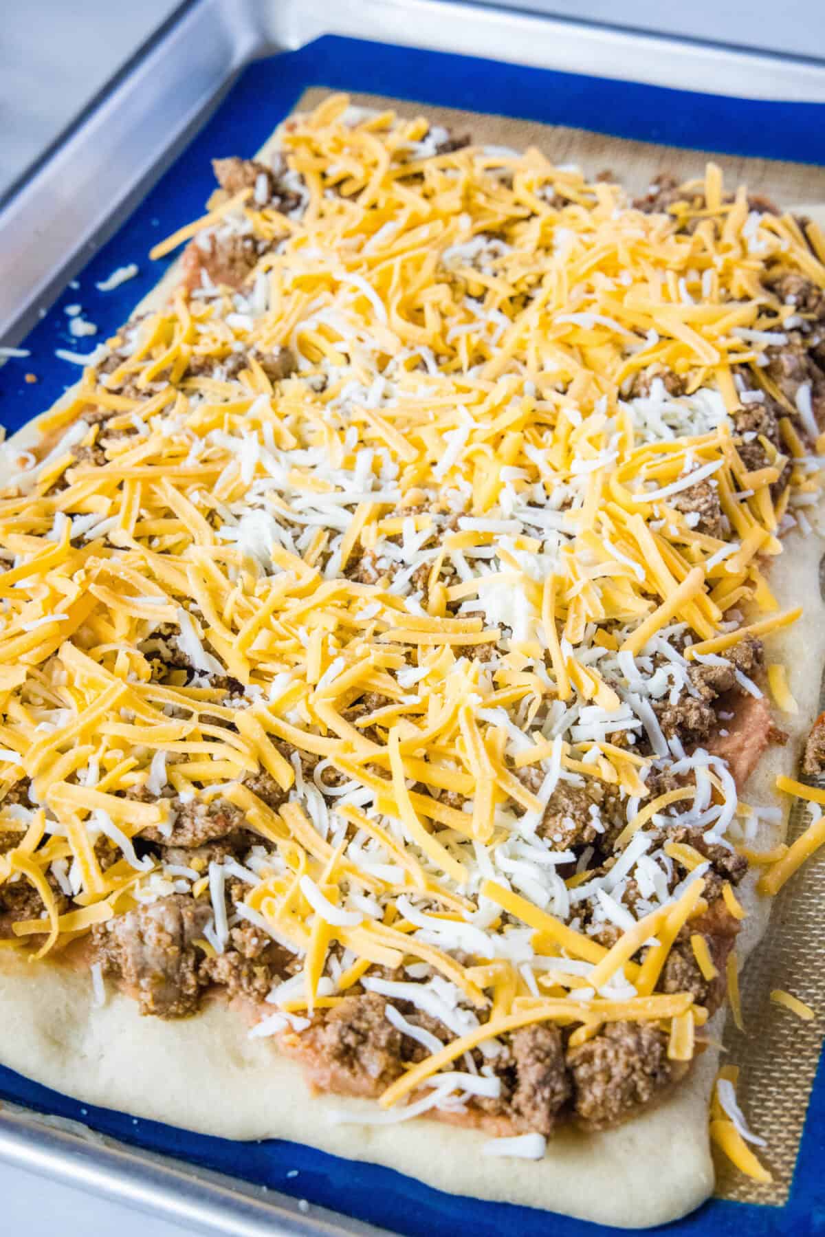 cheese over taco meat on pizza crust