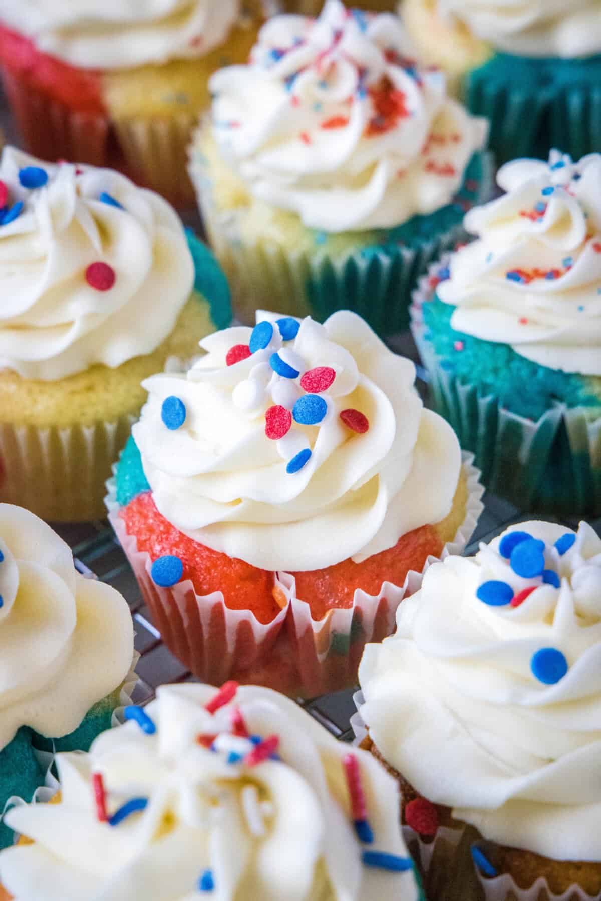 decorated red white and blue cupcakes on platter