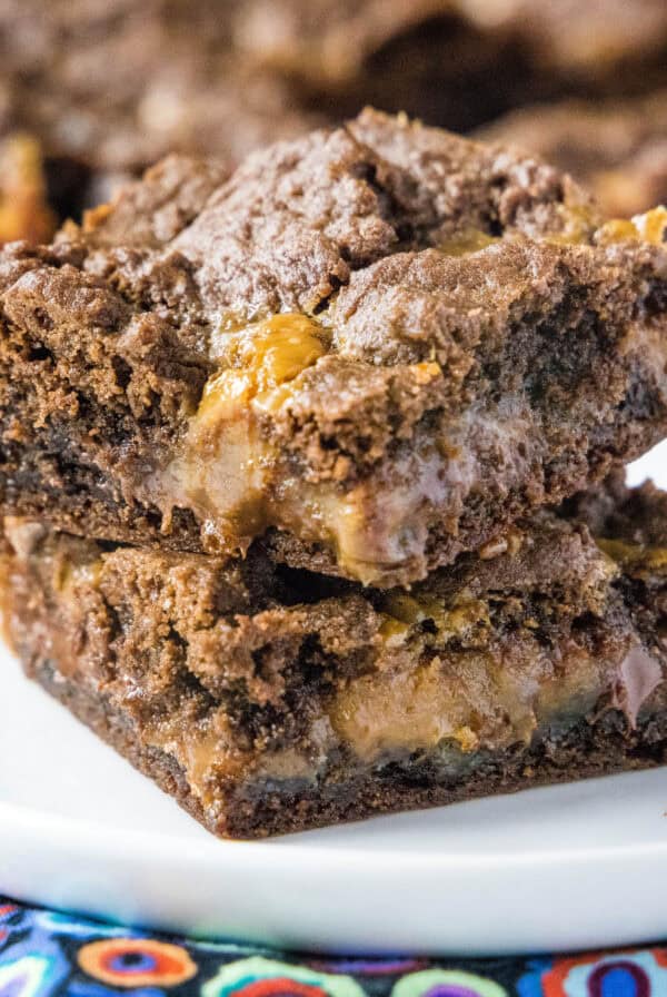 cropped close up caramel layer bars stacked on a plate