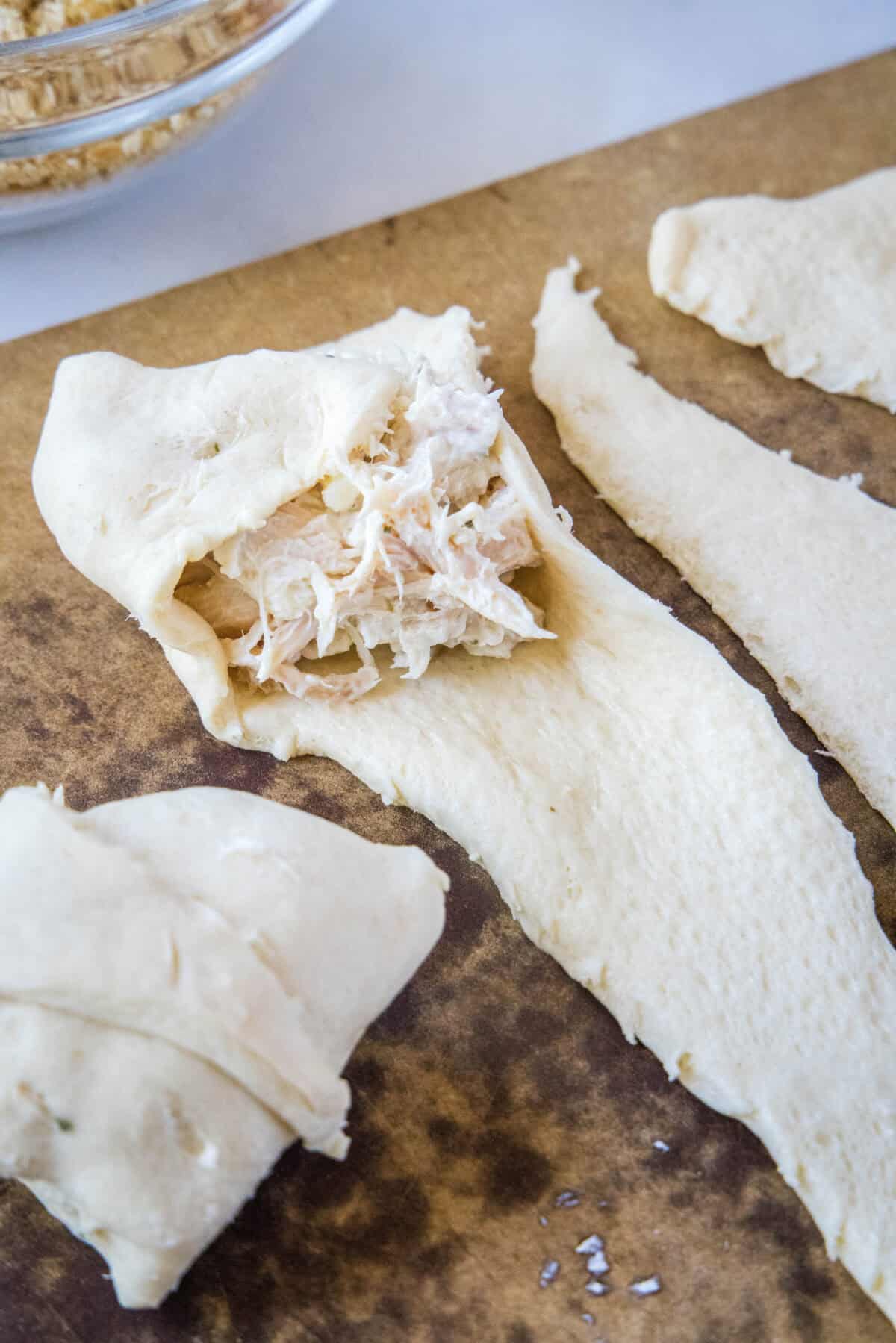 folding the side over the chicken to roll up
