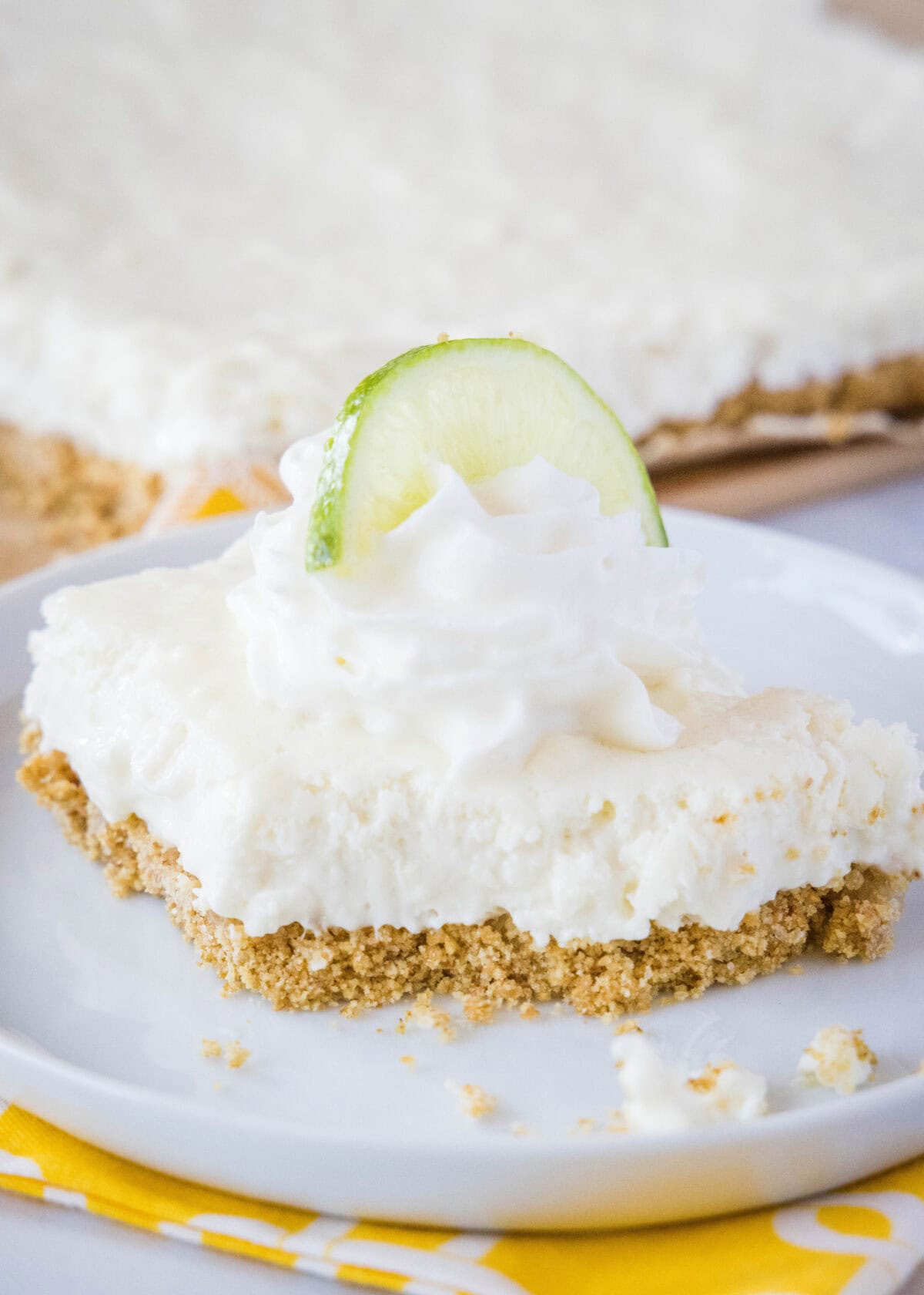 Key Lime Margarita Squares #recipe | Dinners, Dishes, and Desserts key lime bars with a bite taken out of them on a plate
