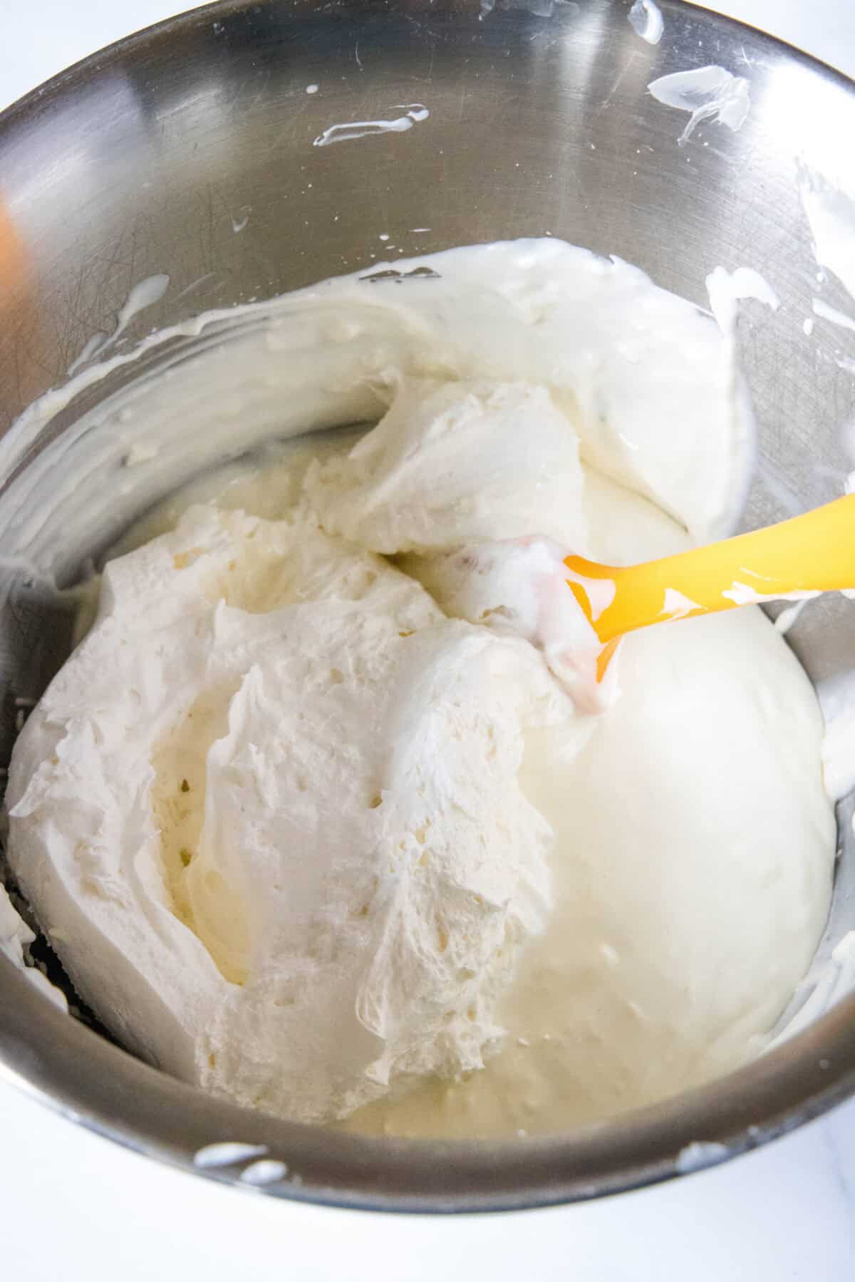 adding whipped cream to key lime cheesecake filling