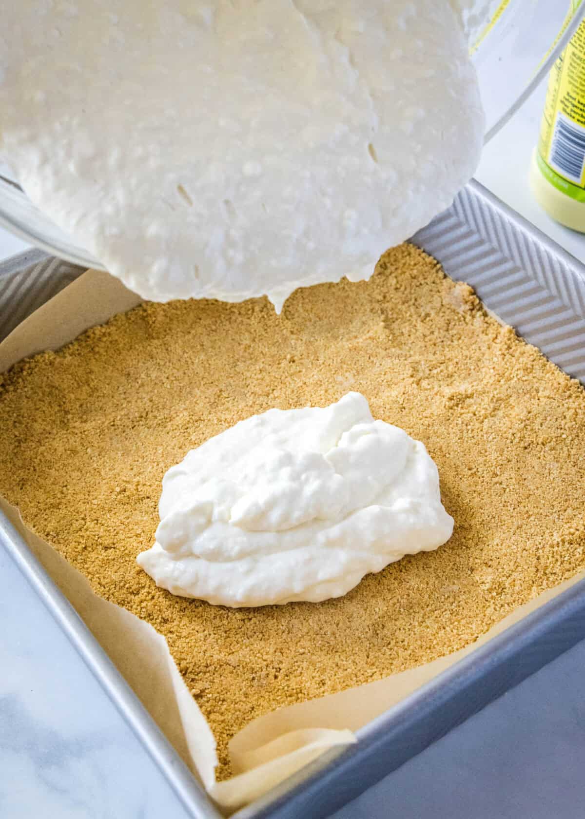 pouring key lime filling over a graham cracker crust
