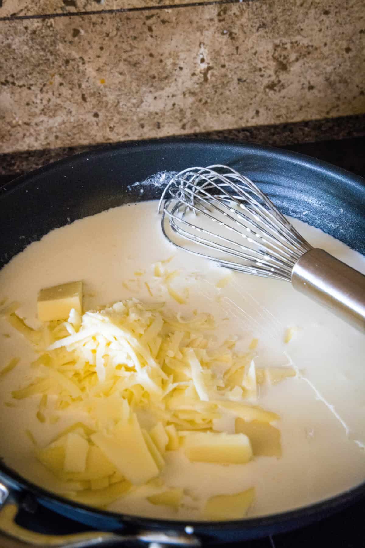 adding cheese to roux in a skillet
