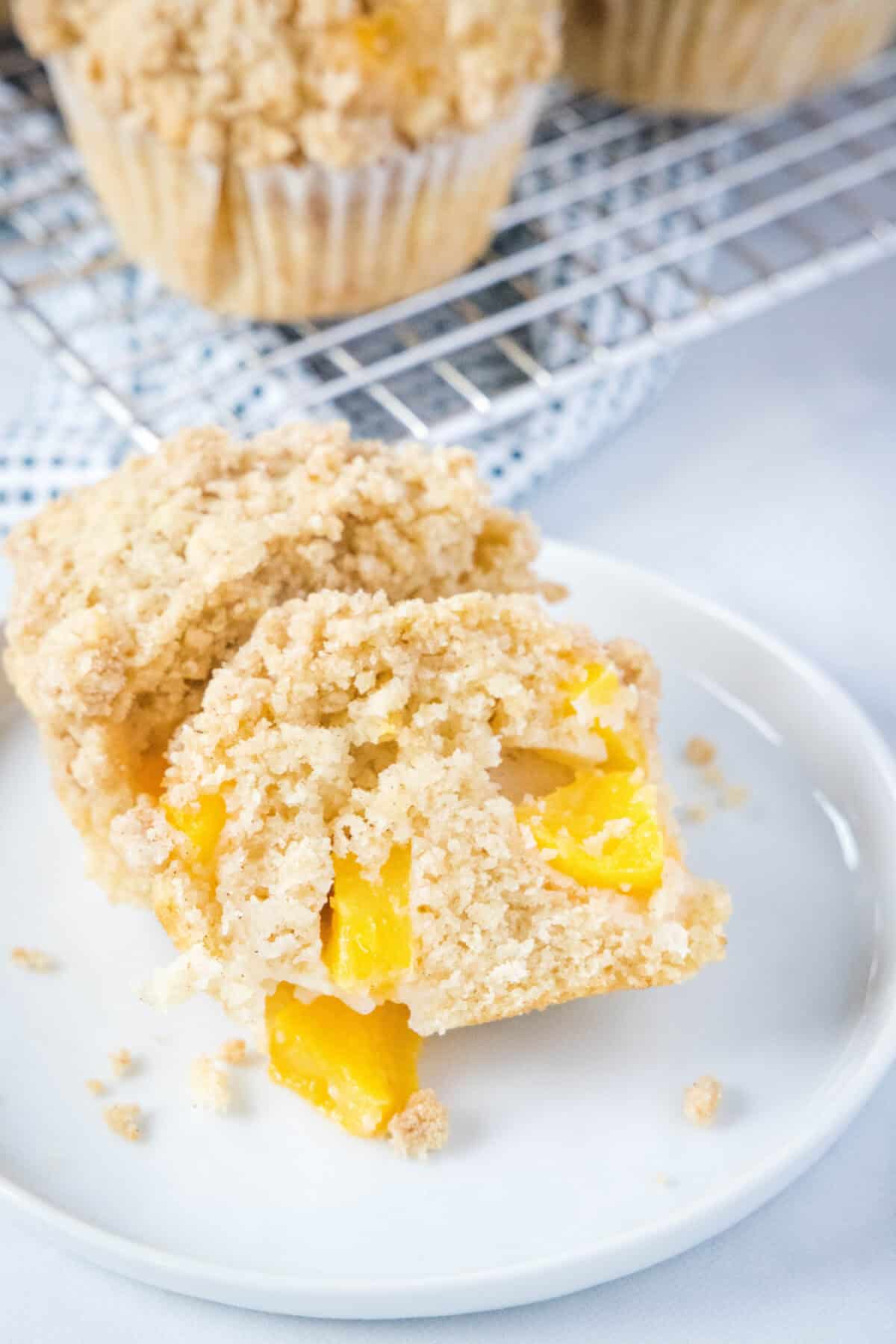 peach cobbler muffin cut in half on a plate