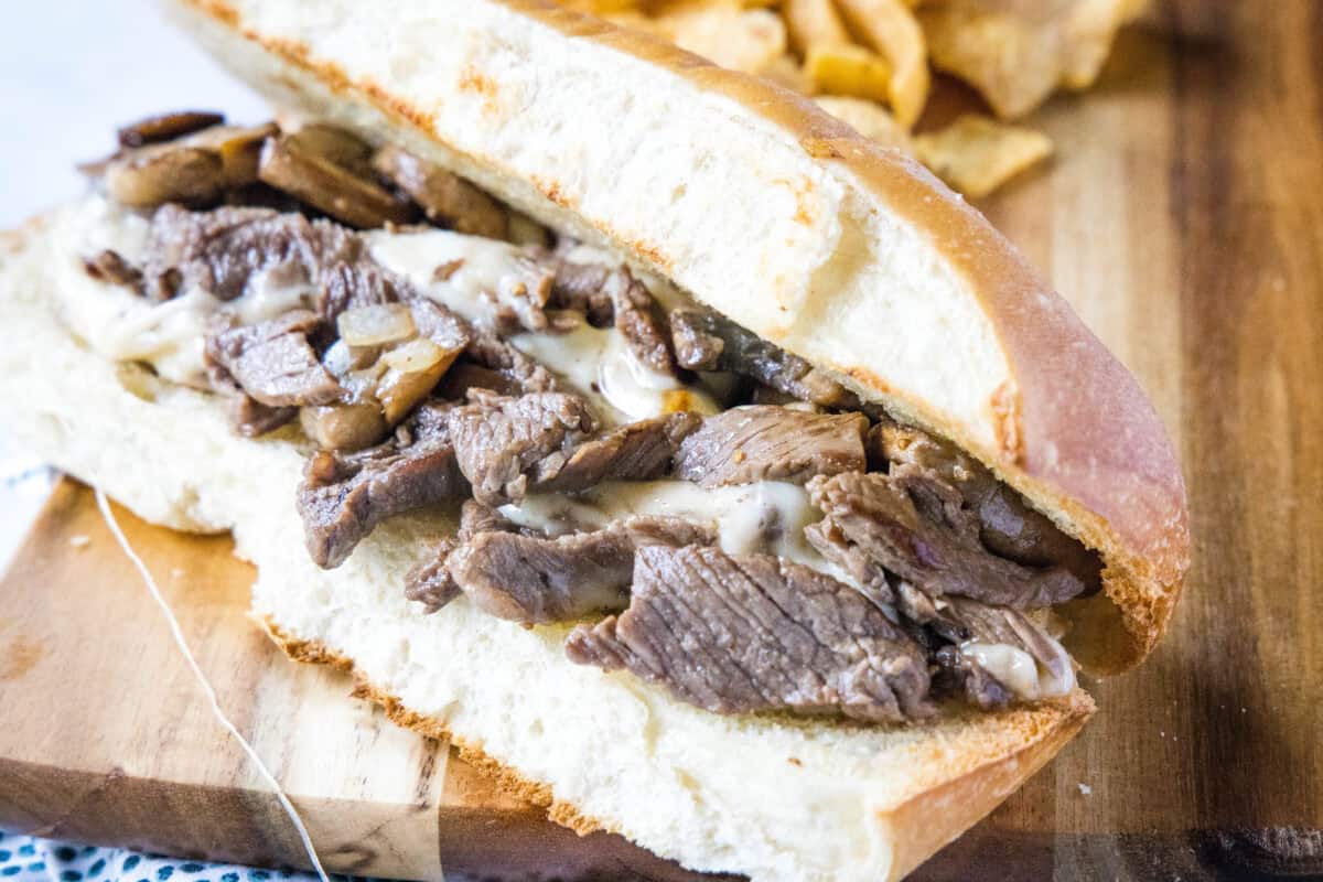 Learn how to make a classic Philly Cheesesteak at home with tender ribeye, sautéed onions, and melted provolone on a toasted hoagie roll.